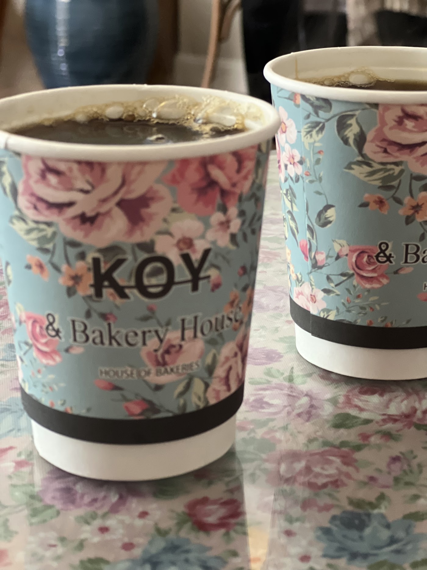 أكواب قهوة KOY بنقشة الورد وعليها الشعار
